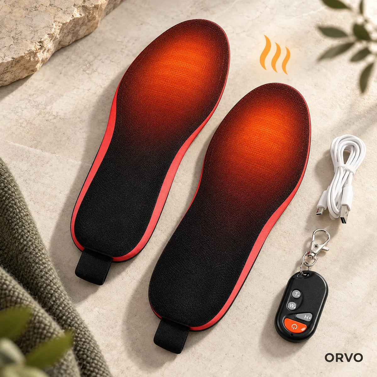 Solette riscaldanti accese con luce calda sulle dita, accanto a telecomando e cavo USB